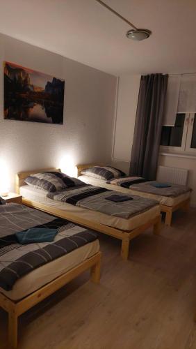 two beds sitting in a room with lights on at Monteurwohnung und Ferienwohnung TMS 18 O in Wefensleben