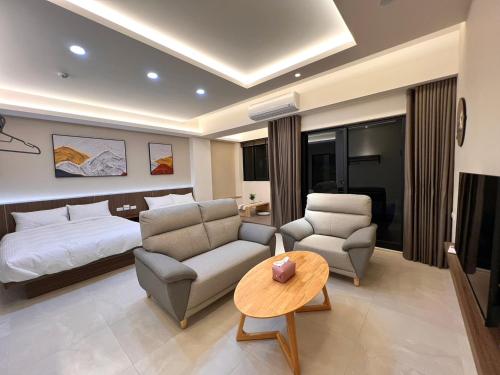 ein Hotelzimmer mit einem Bett, einem Sofa und einem Tisch in der Unterkunft Mandarin Fish Homestay in Magong