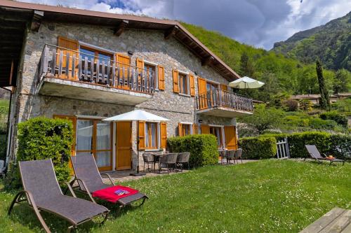 a house with chairs and tables and a balcony at Casa Paola in Vesta