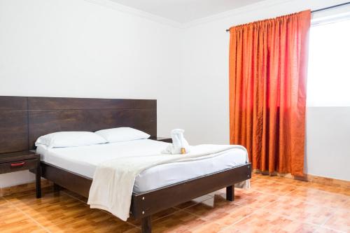1 dormitorio con cama y cortina roja en HOTEL FUENTE DE ORO, en Amalfi
