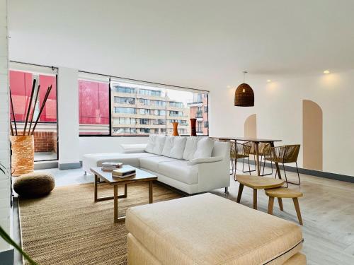 a living room with a white couch and a table at Penthouse Chicalá Colombian Experience in Parque Virrey in Bogotá
