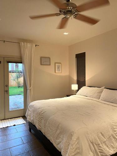 a bedroom with a bed with a ceiling fan at Beautiful first floor suite with backyard, near Downtown and stadiums in Houston