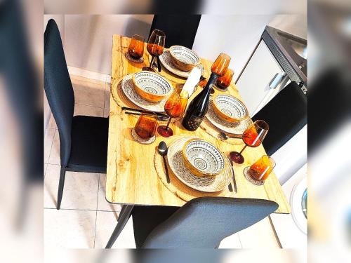 une table en bois avec des assiettes et des verres dans l'établissement Le stanze del tramonto di Eleni, à Lipsi