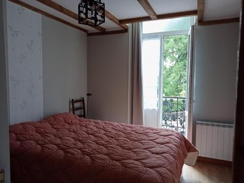 une chambre avec un lit et une grande fenêtre dans l'établissement Villa lutins Gentianes, à Le Mont-Dore