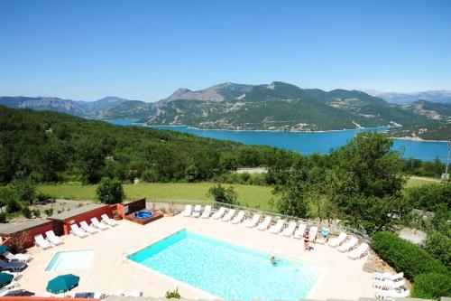 een zwembad met stoelen en uitzicht op het water bij La Palatriere in Le Sauze-du-lac