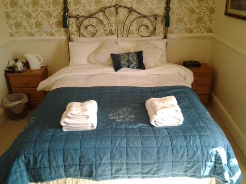 a bedroom with a bed with two towels on it at No. 9 Guest House in Llandudno