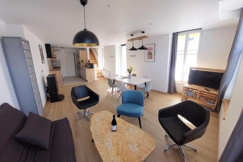 - un salon avec un canapé, des chaises et une table dans l'établissement La Cigogne, moderne, spacieux et bien placé, à Thury-Harcourt