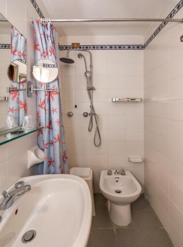 a bathroom with a sink and a toilet and a shower at Hotel Tahiti in Viareggio