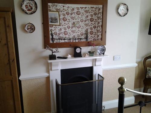 a living room with a fireplace and a picture on the wall at No. 9 Guest House in Llandudno