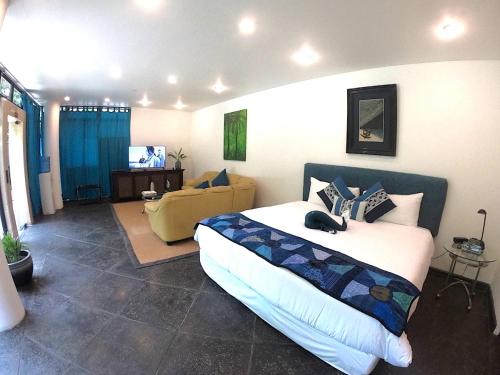 a bedroom with a bed and a couch in it at Suite 9, Manuel Antonio in Quepos