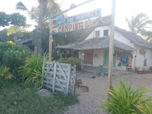 a sign in front of a small house with a store at Suíte beija-flor in Camaçari