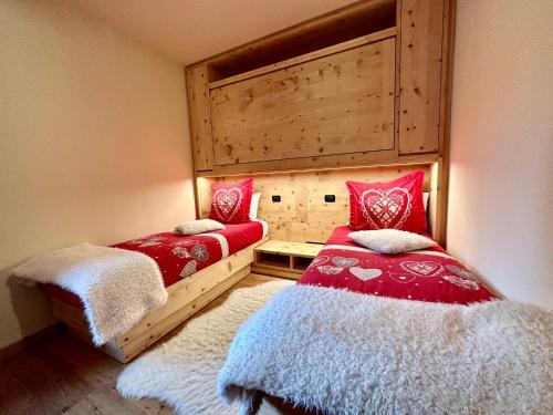 a bedroom with two beds with red and white pillows at Chalet Bormino 5 in Bormio