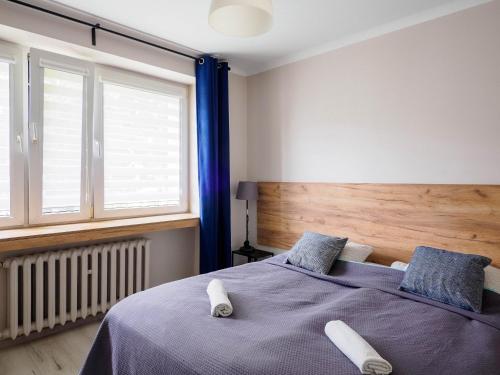 a bedroom with a bed with two slippers on it at VISTULA Grand two-bedroom Apartment ul Okrzei in Płock