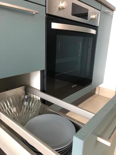 La cocina está equipada con microondas y lavavajillas. en Strasbourg appartement moderne, en Estrasburgo