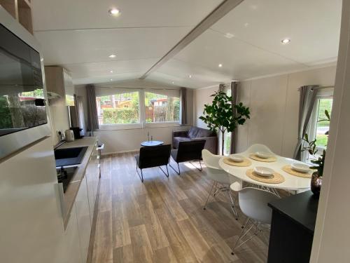 a kitchen and living room with a table and chairs at Chalet in de Veluwse bossen in Hoenderloo