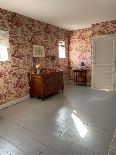 a room with a dresser and pink wallpaper at Belle Fontaine in Bourges