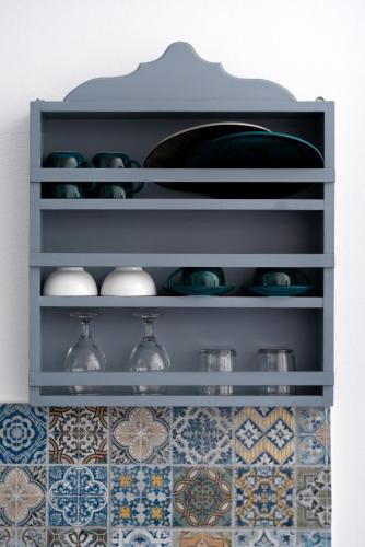 a shelf with plates and bowls on it in a kitchen at 1812 Caves 'n Mansion in Karterados
