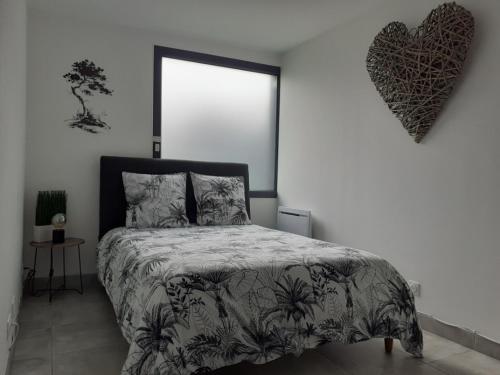 a bedroom with a bed and a heart on the wall at Les pins de Talant , au calme en rez de jardin in Talant
