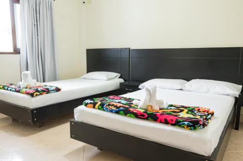 two beds with stuffed animals on them in a room at HOTEL FUENTE DE ORO in Amalfi