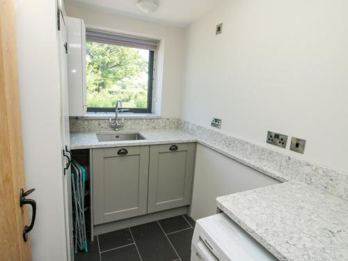 a kitchen with a sink and a window at The Mission Room in Malpas