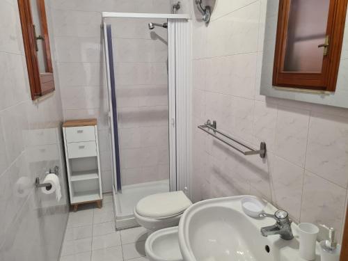uma casa de banho com um WC, um lavatório e um chuveiro em Venere Home em Metaponto