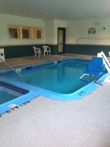 a large swimming pool with blue water in a building at Americas Best Value Inn Somerville Texas in Somerville