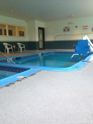 a swimming pool with a blue chair in a building at Americas Best Value Inn Somerville Texas in Somerville