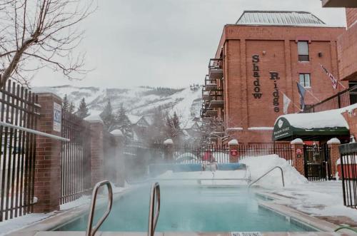 a swimming pool covered in snow in front of a building at Luxe Park City Mountain Resort Studio in Park City