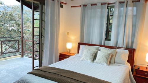 um quarto com uma cama e uma grande janela em Tu Cabaña en Boquete em Alto Boquete