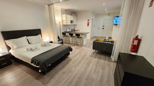 a bedroom with a large bed and a kitchen at Original Studio Downtown in Albufeira