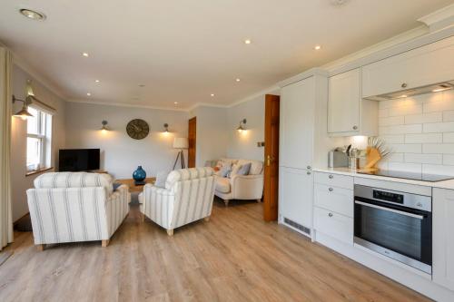 a kitchen and living room with two chairs and a table at Beachcombers Apartments in Newquay