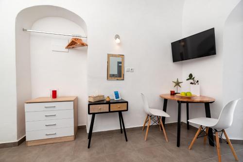 a living room with a table and chairs and a tv at 1812 Caves 'n Mansion in Karterados
