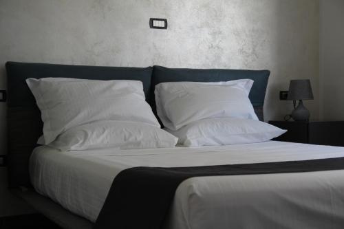 a bed with white pillows and a blue headboard at Dimora Due Galli in Ponti Sul Mincio