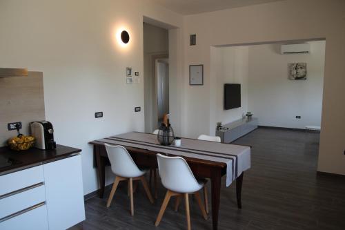 a kitchen with a table and some white chairs at Dimora Due Galli in Ponti Sul Mincio