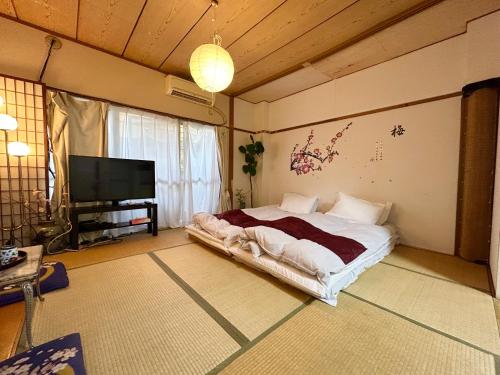 a bedroom with a bed and a flat screen tv at Shinjuku Shin-Okubo Station Nippon no Yado in Tokyo