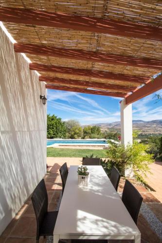 a table and chairs on the patio of a house at Casa con piscina caminito del rey in Alora