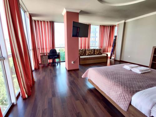 Schlafzimmer mit roten Vorhängen, einem Bett und einem Sofa in der Unterkunft Micromegas apartments in Czernowitz