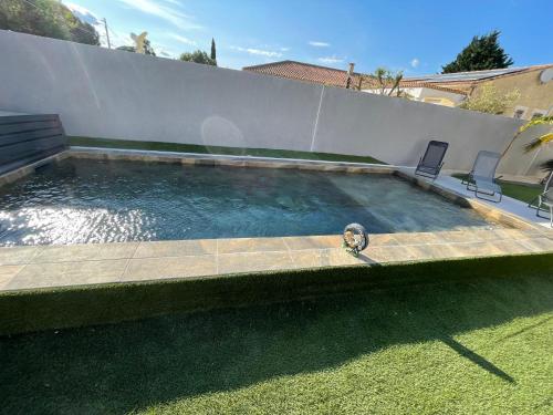 une piscine avec deux chaises et une tortue dedans dans l'établissement Villa Grand Nicolas Bord de Mer, au Grau-dʼAgde