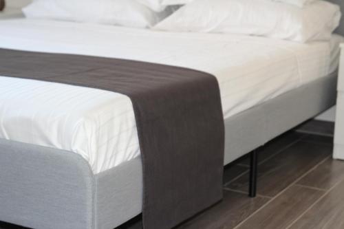 a bed with white sheets and a brown blanket at Dimora Due Galli in Ponti Sul Mincio