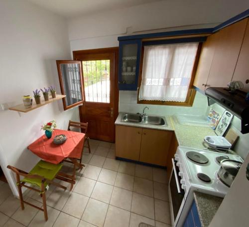 Una pequeña cocina con una mesa y un fregadero. en View Sea House, en Kato Gatzea