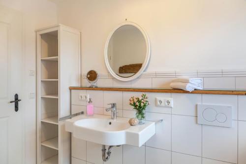 a white bathroom with a sink and a mirror at Lisbeth in Rottenbuch