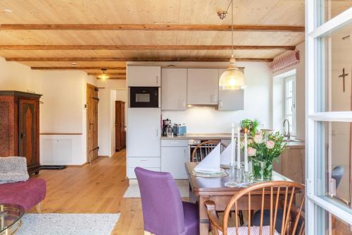 a kitchen and dining room with a table and purple chairs at Lisbeth in Rottenbuch