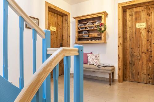 a staircase with a blue rail and a chair in a room at Lisbeth in Rottenbuch