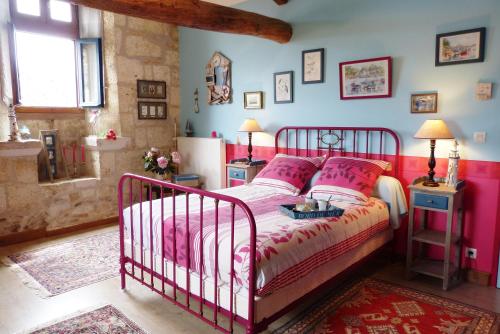 a bedroom with a bed with pink and white sheets at L'Echappée Belle Périgord in Cercles
