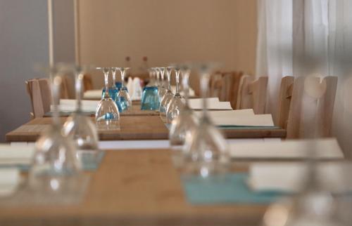 a long wooden table with wine glasses on it at Hotel Santiago in Milano Marittima