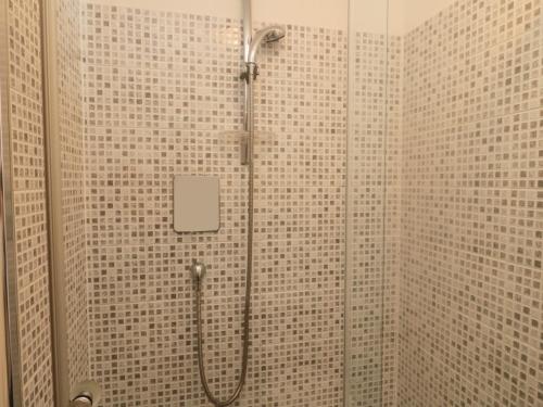 a shower in a bathroom with tiled walls at Orchard Lodge in Warkworth