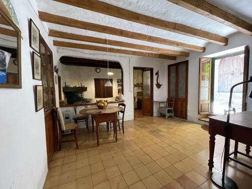 a kitchen and dining room with a table and chairs at Encantadora Casita en el Centro de Fornalutx in Fornalutx