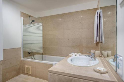 a bathroom with a sink and a bath tub at Swiss Green Appartement Cosy et Spacieux in Quarteira