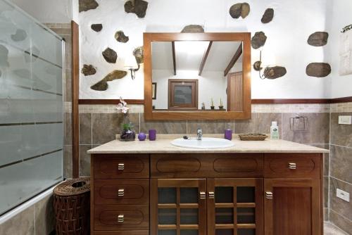 uma casa de banho com um lavatório e um espelho em Casa Abuelo Paco em Vega de San Mateo