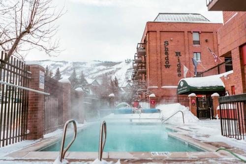 ein schneebedeckter Pool neben einem Gebäude in der Unterkunft 2 Bd/3 Ba, Luxury Ski-in Ski Out Condo - Sleeps 10 in Park City